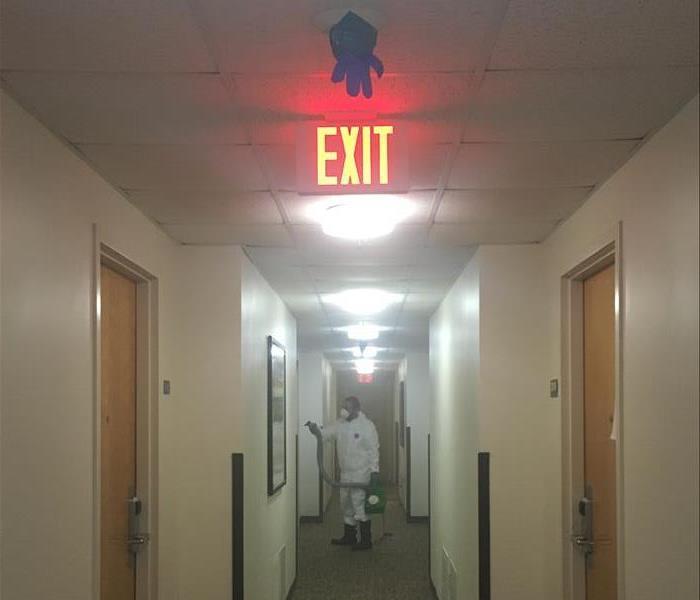 SERVPRO technician disinfecting a hallway