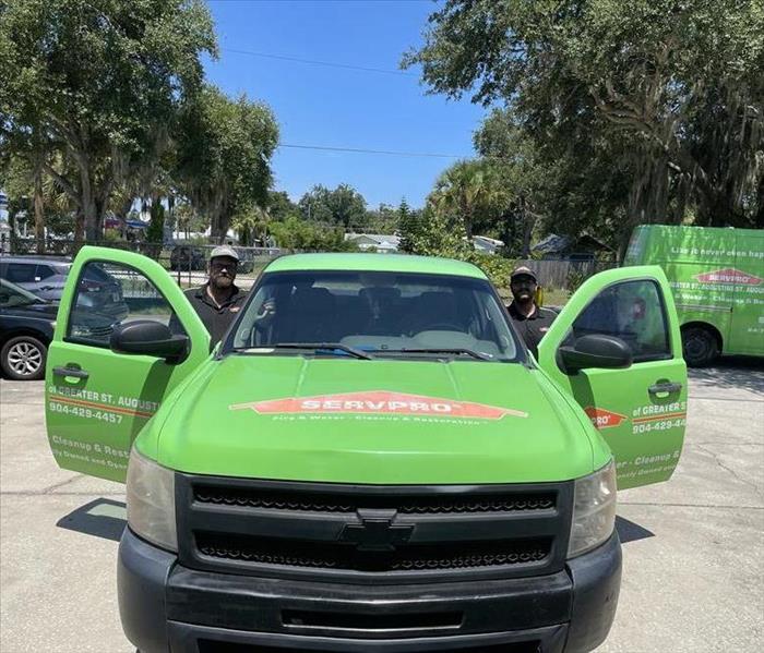 a pic of our SERVPRO branded truck and our two guys leaning out each side of the truck smiling for the picture. 